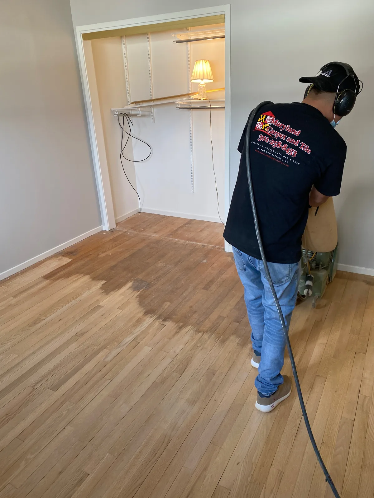 Maryland Carpet and Tile technician refinishing a hardwood floor